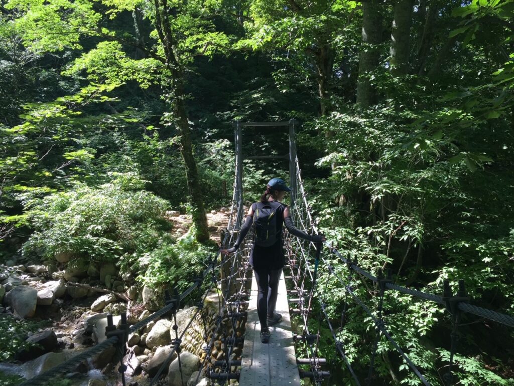 以東岳登山途中の七ツ滝沢に架かる吊り橋を渡る様子を撮影した写真