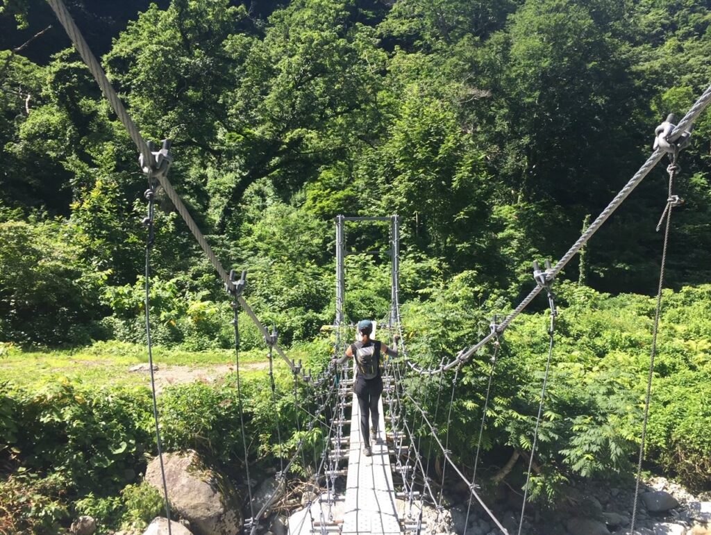 以東岳登山途中の冷水沢に架かる吊り橋を渡る様子を撮影した写真